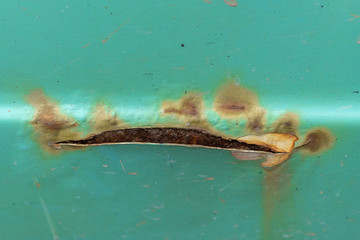 Close up photo of old rusty scratch on the car body.