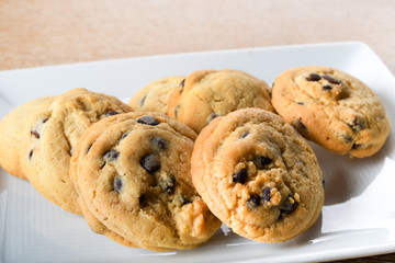 Homemade vanilla, orange, lemon chocolate chip cookies biscuits stack on a white plate