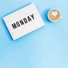 Text "monday" on lightbox for holiday - Thank God It’s Monday. Start of working week concept. Top view on blue background.