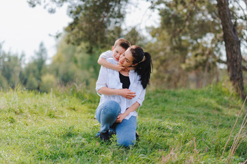 Fototapeta premium Happy family! Mother with son child playing having fun together on the grass in sunny summer day, life moment