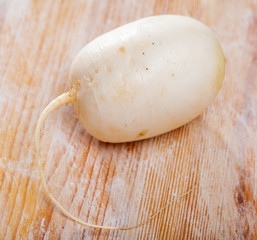 One white turnip on wooden table