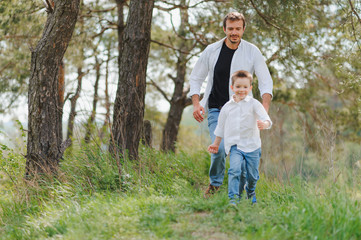 Fototapeta na wymiar father and son have fun together in nature. Father and son playing. People having fun outdoors. Concept of friendly family.