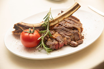 Grilled meat on a white plate in a served restaurant