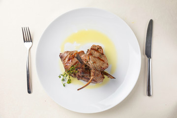 Grilled meat on a white plate in a served restaurant