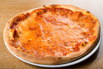 Pizza Margherita on brown table background, top view. Pizza Margarita with Tomatoes, mozzarella