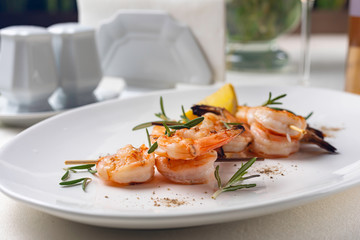 grilled shrimp on a white plate in a restaurant