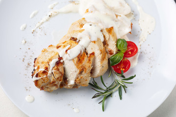 Grilled meat on a white plate in a served restaurant