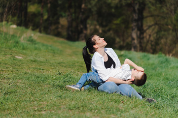 Stilish mother and handsome son having fun on the nature. Happy family concept. Beauty nature scene with family outdoor lifestyle. Happy family resting together. Happiness in family life. Mothers day.