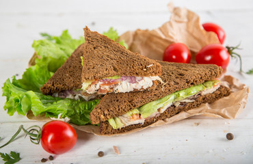 Club sandwich with chiken and cucumbers on dark rye bread
