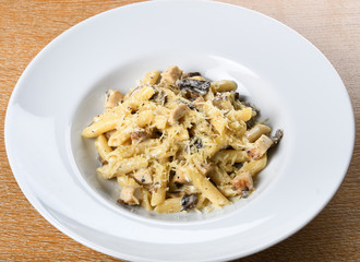 Traditional authentic italian penne al pollo e funghi pasta with mushroom ,chicken, parmesan cheese.