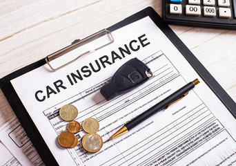 Car insurance concept with calculator on wood table