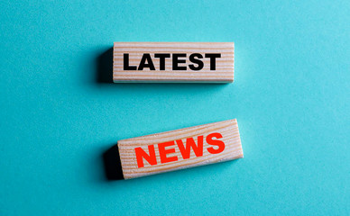 The phrase latest news is written on wooden blocks on a blue background