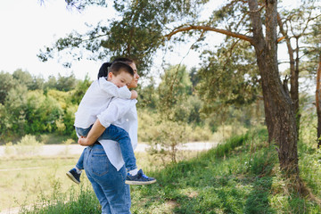 Stilish mother and handsome son having fun on the nature. Happy family concept. Beauty nature scene with family outdoor lifestyle. Happy family resting together. Happiness in family life. Mothers day.