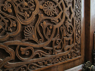 Traditional uzbek ornament on the door. Wood carving. Texture background close-up