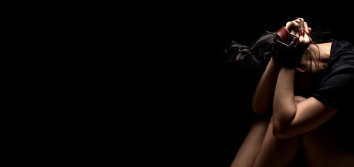 Woman tied up with leather belt in emotional stress and pain