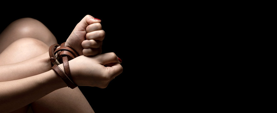 Woman tied up with leather belt in emotional stress and pain