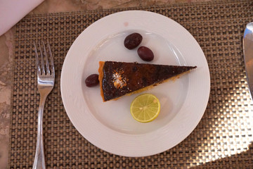 Lemon chocolate cake on a white plate with lemon