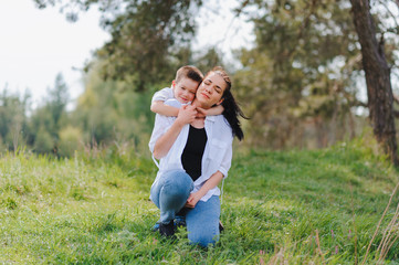 Stilish mother and handsome son having fun on the nature. Happy family concept. Beauty nature scene with family outdoor lifestyle. Happy family resting together. Happiness in family life. Mothers day.