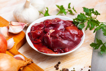 Picture of raw chicken liver with garlic and greens