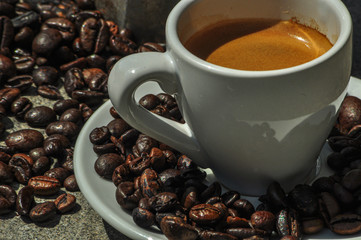 cup of coffee over a lot of coffee beans background 