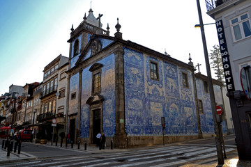 Fototapeta na wymiar Porto, Portugal - August 17, 2015: Focus on the church la Capela das Almas. Its facade is covered with Azulejos. The tiles show the lives of Saint Catherine and Saint Francis of Assisi.