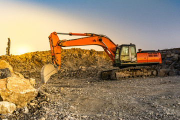 Excavator moving stone and rock at a construction site