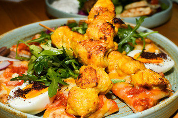 Chicken tandoori with rucola salad, egg with sumac spice, pitta bread. Asian dish