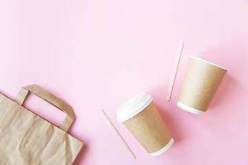 Set with disposable environmental paper utensils on pink background