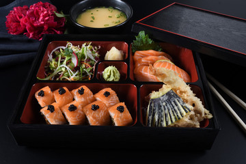 Fresh Food Portion in Japanese Bento Box with Sushi Rolls, Salad and Main Course.Rice and Fried Meat