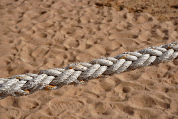 Thick natural rope on the background of sand