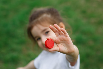 A little girl holds plastic bottle caps in her hands. Volunteer charity event 