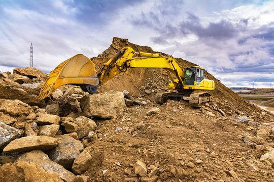 Heavy machinery moving stone and rock in an open mine