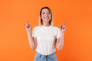 Image of beautiful cheerful woman smiling with fingers crossed