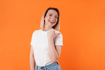 Image of beautiful cheerful woman smiling and pointing finger aside