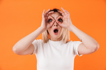 Image of surprised attractive woman grimacing and gesturing ok sign