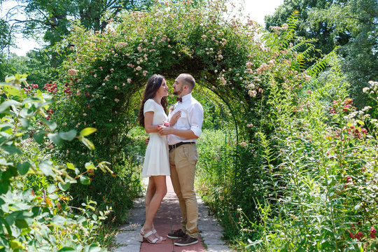Lovers newlyweds. Beautiful couple in love. Loving couple in the garden among the flowers. Just married. Beautiful bride and groom are hugging in the park. Wedding portrait of lovers newlyweds