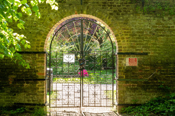The locked garden gate in a brickwall