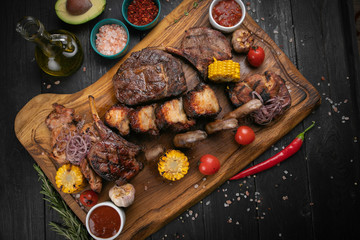 Fototapeta na wymiar Assorted delicious grilled meat with vegetable and herbs on rustic table