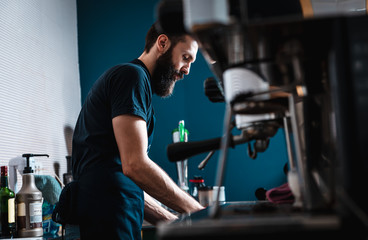 Fototapeta na wymiar Barista preparing cappuccino on espresso machine for customer in coffee shop.