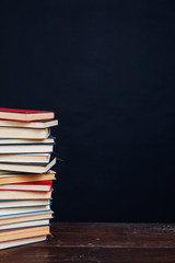 many stacks of educational books to prepare for exams in the university library black background