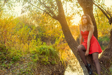 A woman is posing in front of a camera in an autumn park. autumn photo shoot. Autumn in the park.