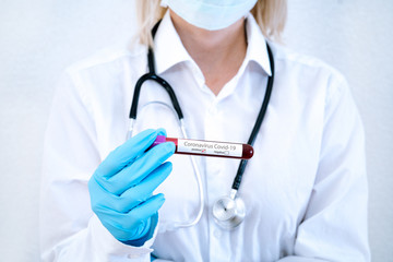 Fototapeta premium Coronavirus Covid-19 outbreaking. Doctor in medical glove and face mask holding tube with blood test result for rapidly spreading Coronavirus 2019-nCoV in laboratory. Medicine and epidemic concept.