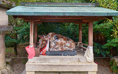 The statue of ox lying down under the roof at Kitano Tenmangu shrine. Kyoto. Japan