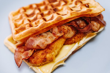 tasty Belgium waffle with lettuce, meat, egg and vegetables served of pretty blue plate