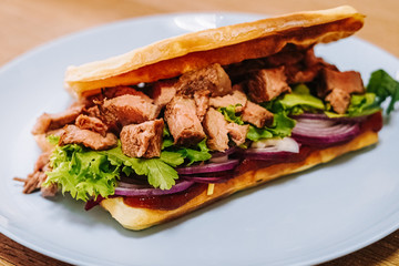 tasty Belgium waffle with lettuce, meat, egg and vegetables served of pretty blue plate