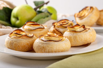 Apple roses puff pastry cakes on white background.