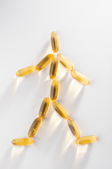 Man figure layed out with omega 3 capsules
