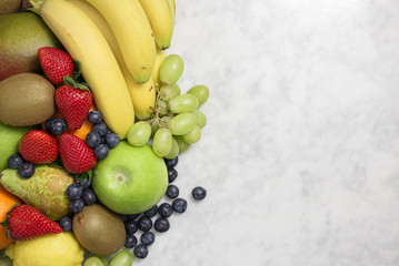 Assortment of healthy fresh fruits on marble background