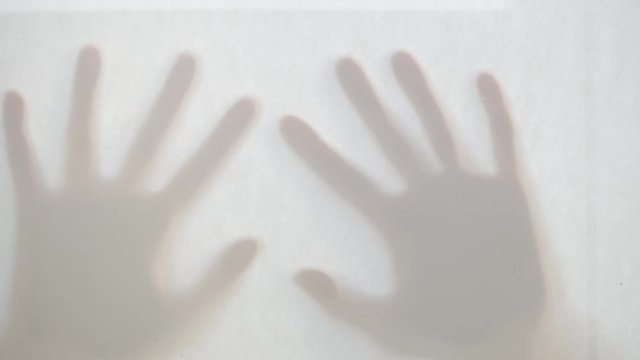There are two ghost shadows of hands.