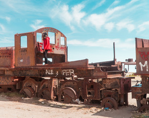 Fototapeta na wymiar Tourist, Train Cemetry Bolivia Salt Flats. Bolivian salty desert and blue sky background. Shot in Salar de Uyuni. Rusted, waste, abandoned, locomotive graveyard, railroad concepts. Tourist attraction
